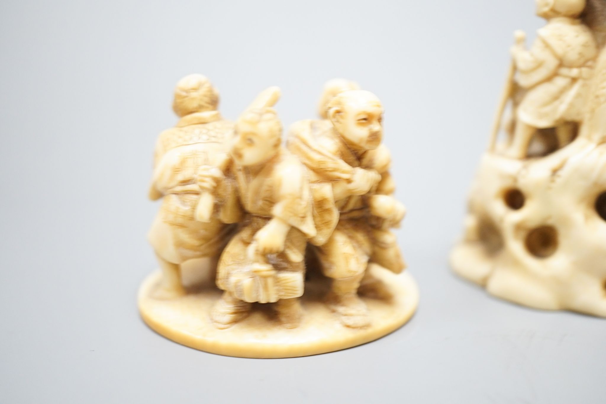 Two Japanese ivory okimono-netsuke of Buddha and attendants and a group of artisans, Meiji period, both signed, tallest 7cm